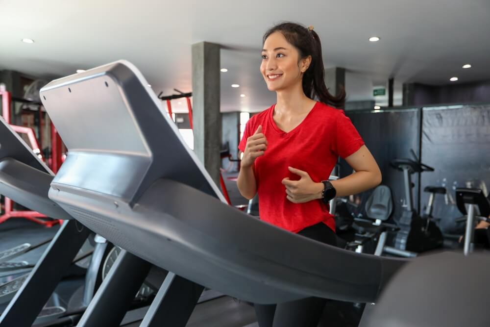 Asian Lady working out on the Best Treadmill for Interval Training